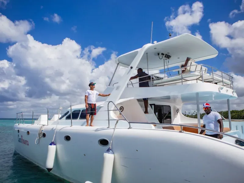 A yacht crew member serving guests on deck